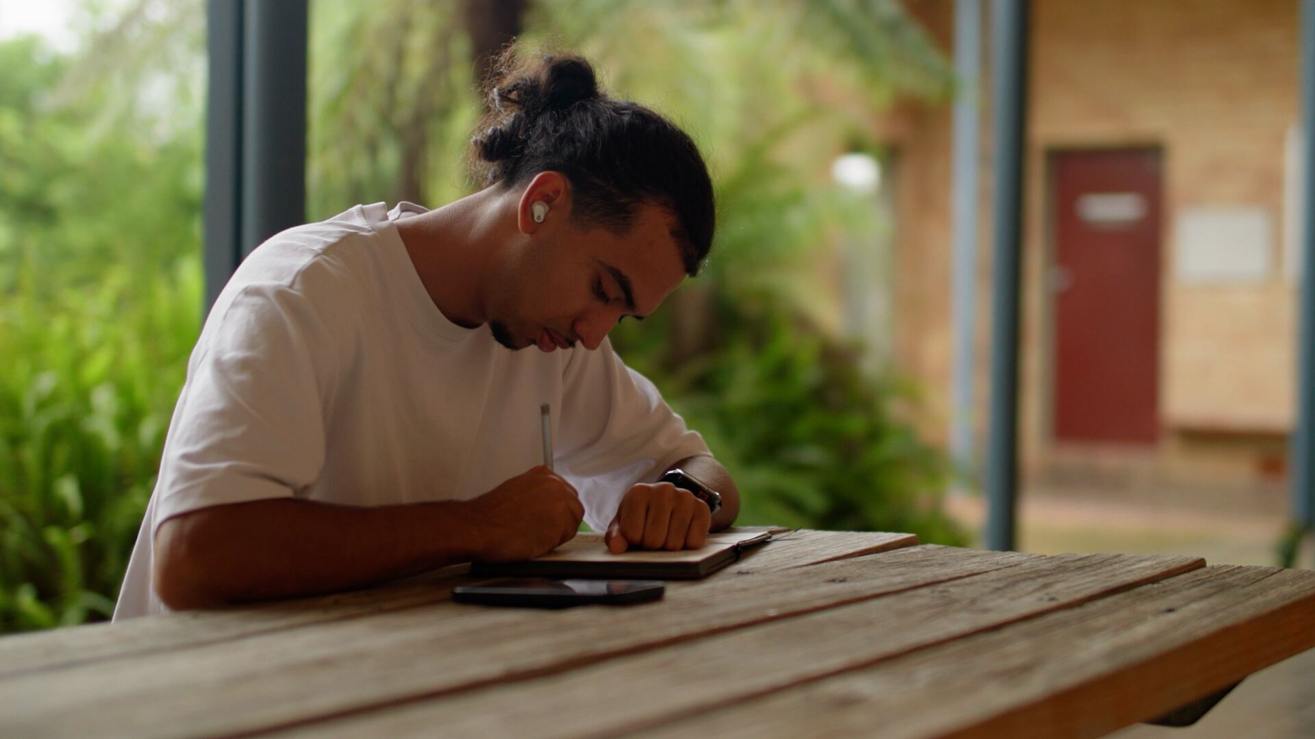 A Catalyst student journaling outdoors